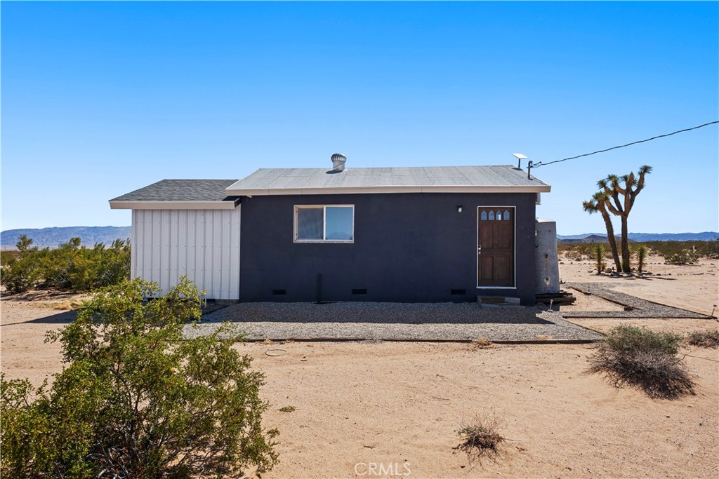 66750 Pole Line Road Joshua Tree, CA 92252 - Photo 31 of 36 a front view of a house with a yard