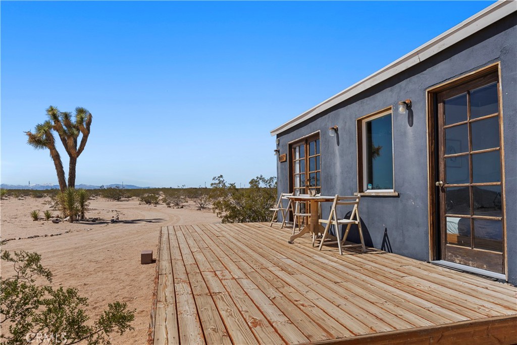 66750 Pole Line Road Joshua Tree, CA 92252 - Photo 33 of 36 a view of a patio with wooden floor and seating space