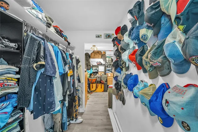 a view of walk in closet with clothes and shoes