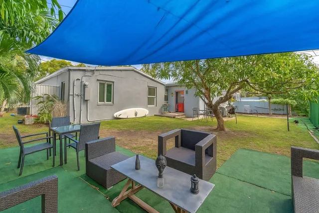 a view of an house with backyard and sitting area