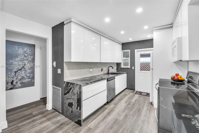 a kitchen with stainless steel appliances granite countertop a stove a sink and a refrigerator