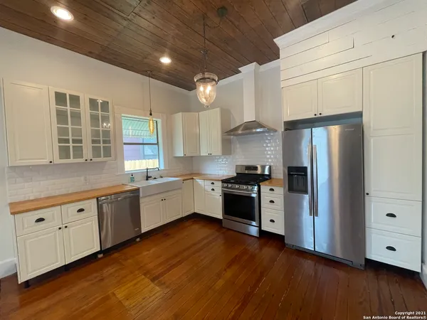 a large kitchen with granite countertop a large counter top space stainless steel appliances and a window