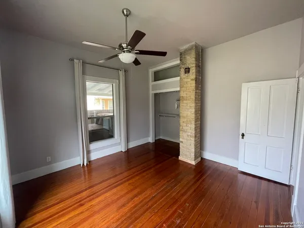 a view of empty room with wooden floor