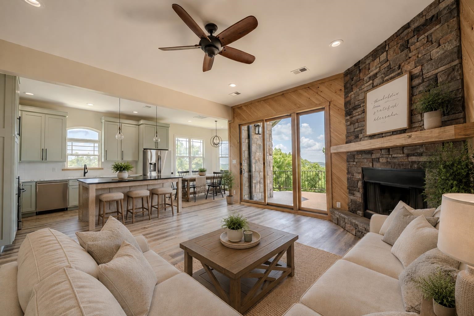 851 Rivers Edge Drive Bath Springs, TN 38311 - Photo 37 of 39 Open-concept living area with wood-finish flooring, a stone-clad fireplace with wood mantel, and sliding glass doors to the exterior