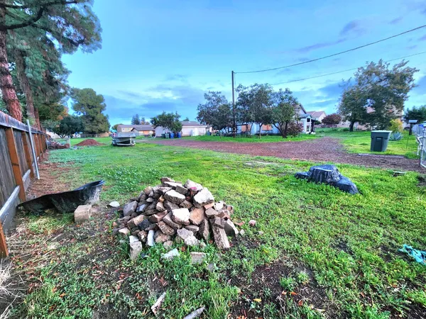 a view of a garden with a bench in front of the house