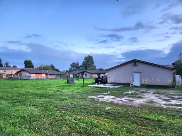 a view of a big yard with a house in the background