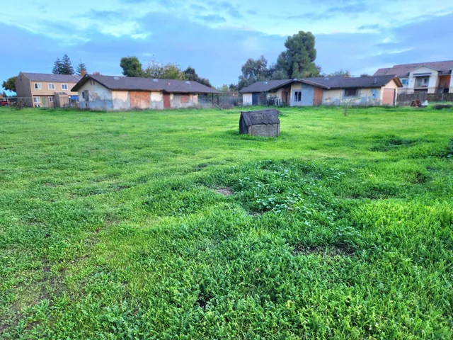 a view of a house with a big yard and large trees