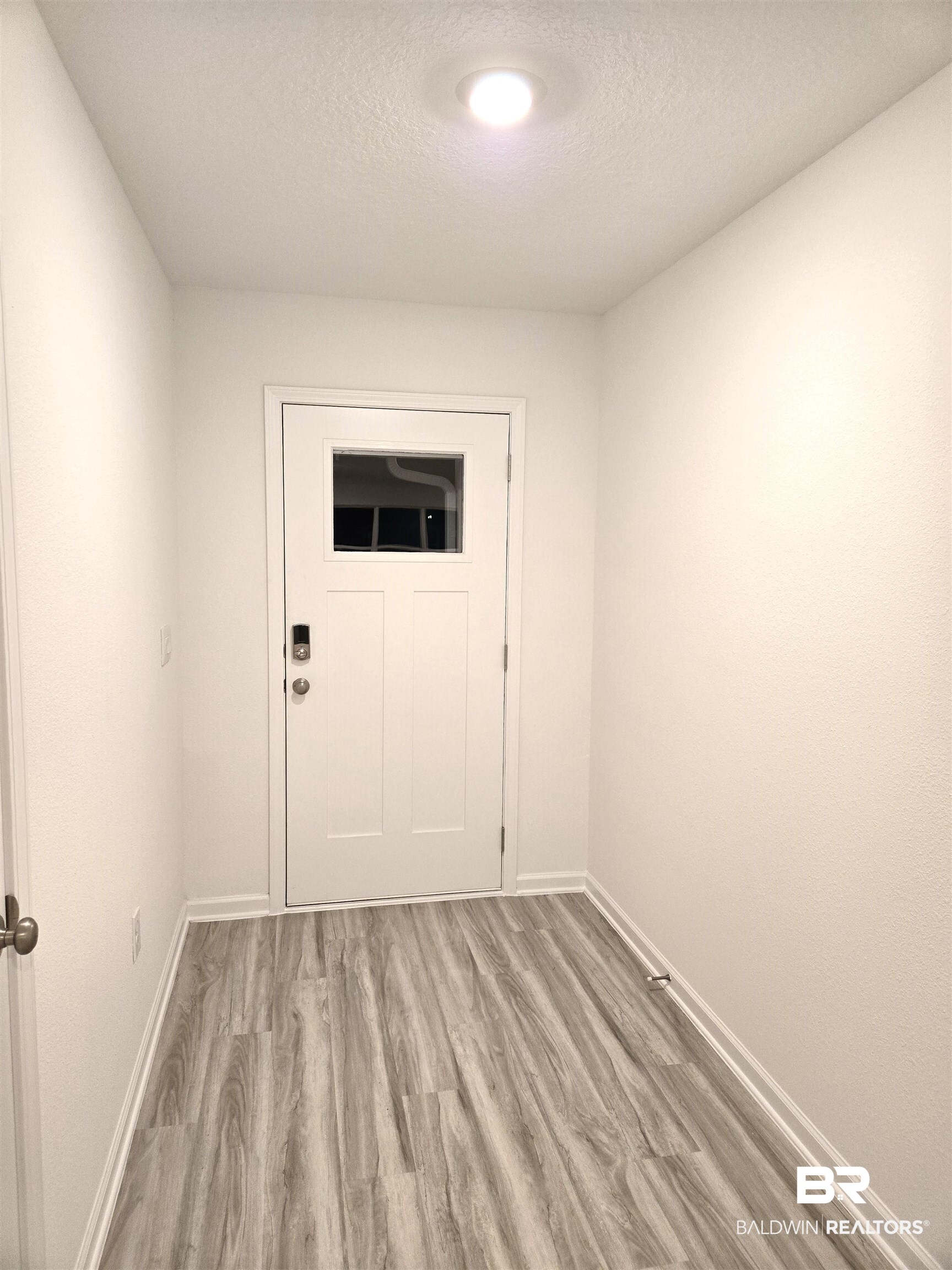 24385 Ringneck Loop Elberta, AL 36530 - Photo 5 of 33 Doorway with light wood-type flooring and a textured ceiling