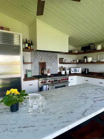 a kitchen with stainless steel appliances wooden cabinets and a stove top oven