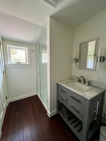 a bathroom with a granite countertop bathtub shower sink and toilet