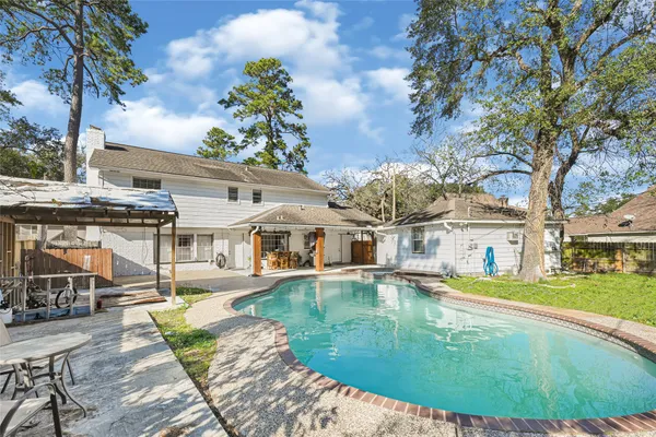 an aerial view of a house with swimming pool and porch