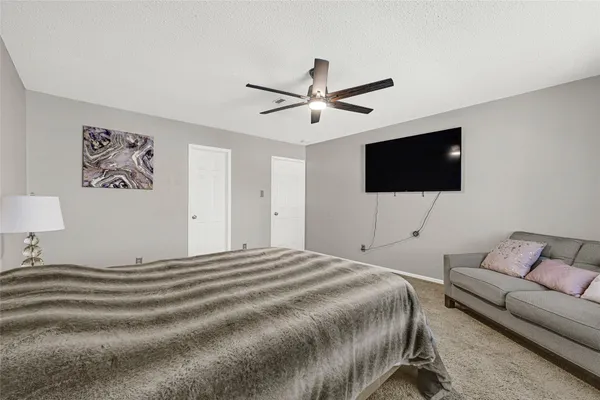 a bedroom with a bed a flat screen tv and a couch