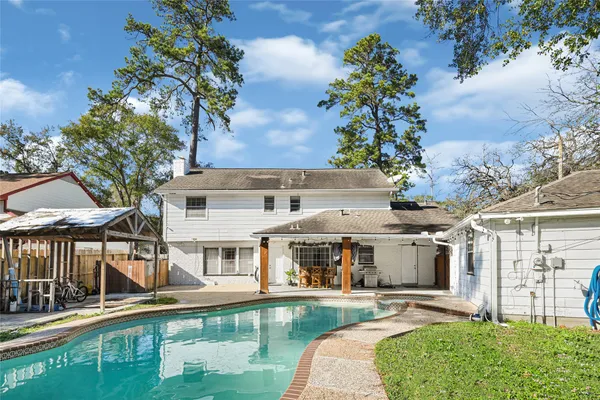 aerial view of a house with swimming pool lawn chairs and a yard