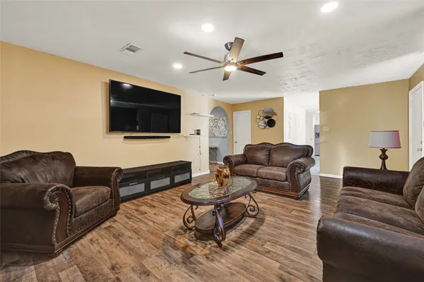 a living room with furniture a flat screen tv and a window