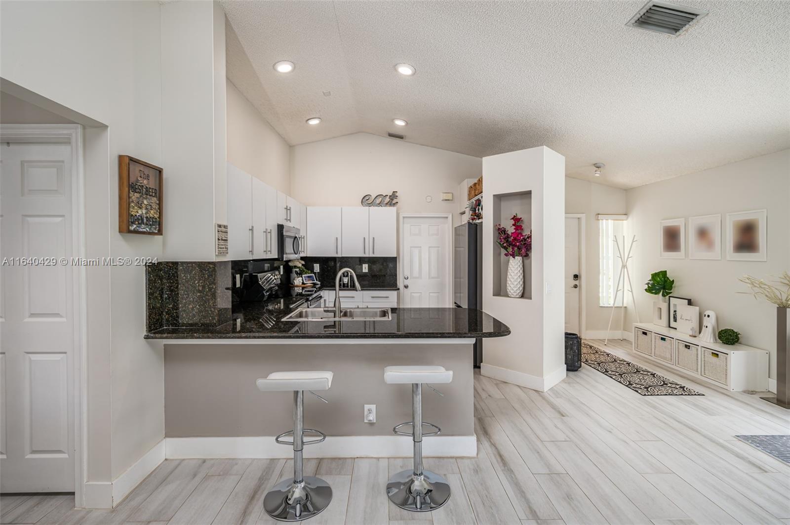 The Ridges Weston, FL 33331 - Photo 7 of 27 a kitchen with stainless steel appliances kitchen island granite countertop a refrigerator and cabinets