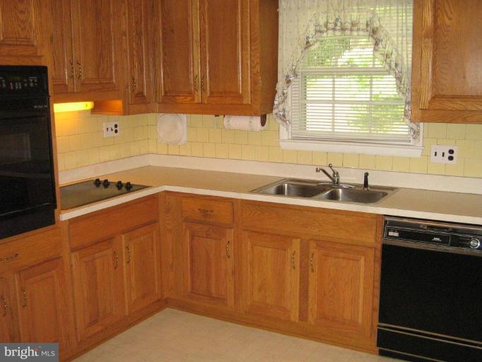 7103 Wardman Road Baltimore, MD 21212 - Photo 8 of 19 a kitchen with stainless steel appliances granite countertop a sink dishwasher a stove and a refrigerator with wooden cabinets