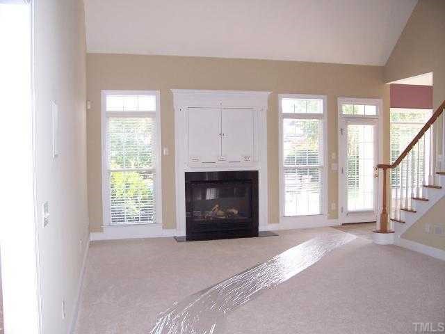 217 Challenge Road Raleigh, NC 27603 - Photo 4 of 12 a view of an empty room with a fireplace and a window