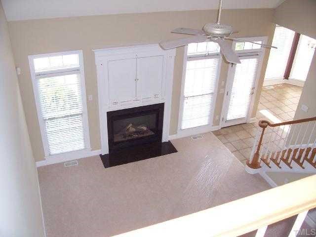 217 Challenge Road Raleigh, NC 27603 - Photo 5 of 12 a living room with furniture a window and a fireplace