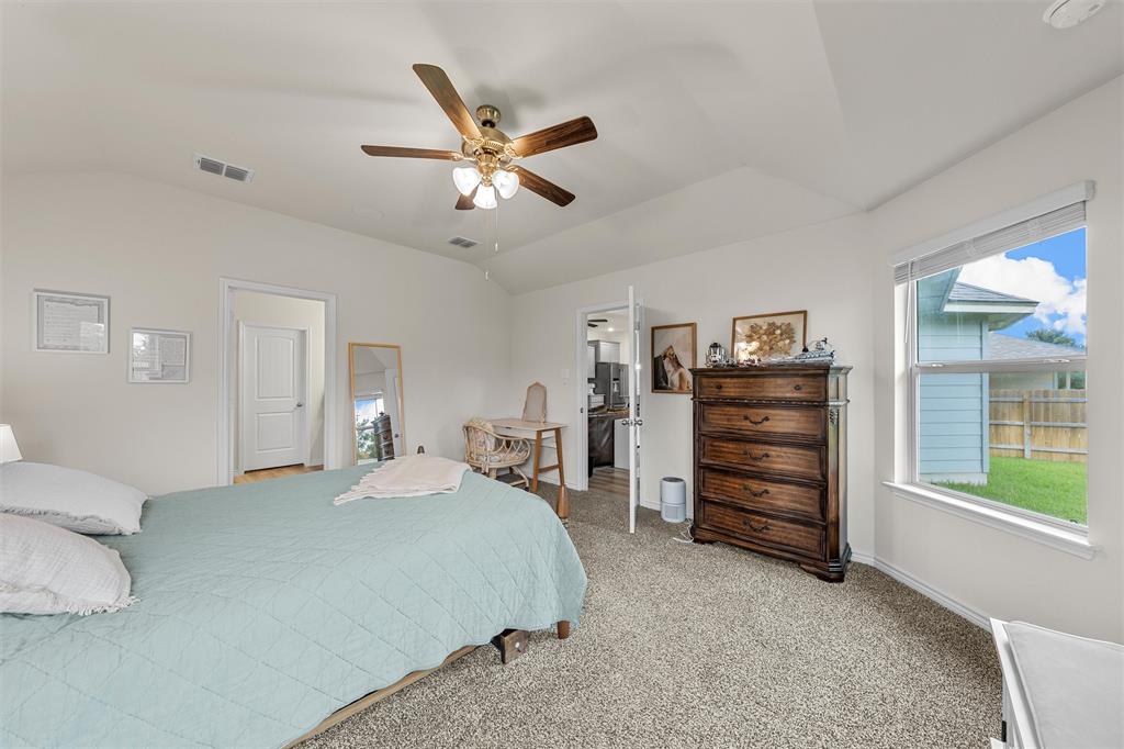 10712 Peperak Court Waco, TX 76708 - Photo 14 of 25 a bedroom with a bed and a chandelier