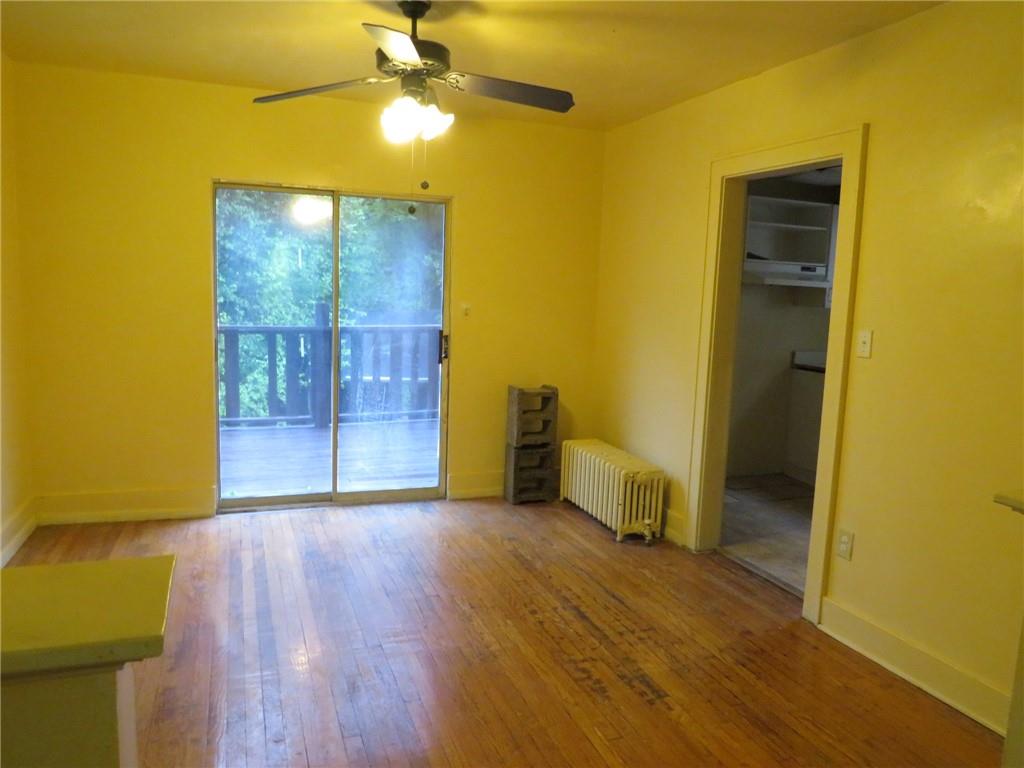 423 Braddock Road Pittsburgh, PA 15221 - Photo 10 of 36 a view of a livingroom with wooden floor and a ceiling fan