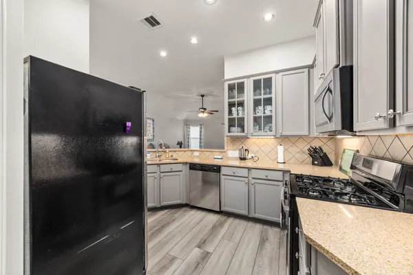 a kitchen with stainless steel appliances granite countertop a sink stove and refrigerator