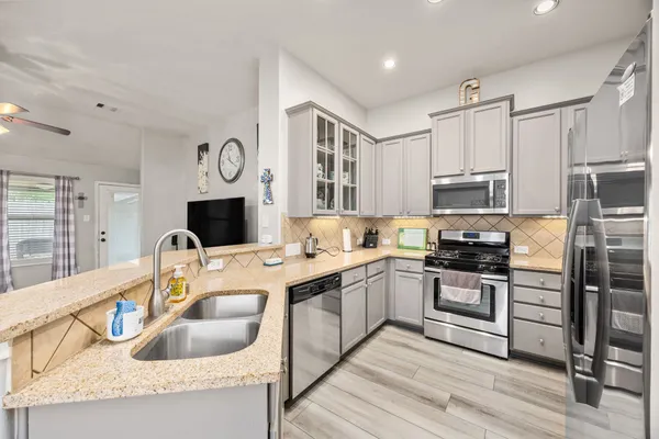 a kitchen with stainless steel appliances granite countertop a sink stove and refrigerator