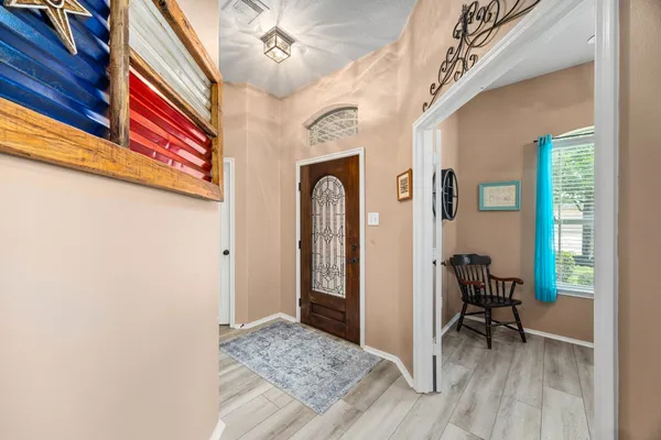 a view of a hallway with furniture and a window