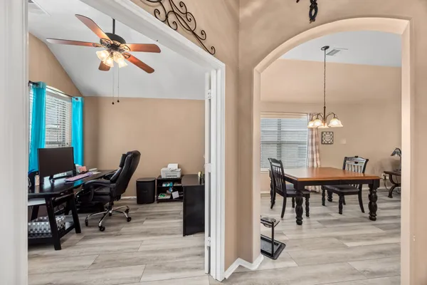 a workspace with wooden floor and a chandelier fan