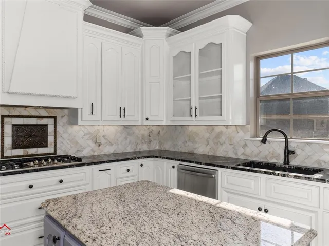 a kitchen with granite countertop white cabinets and stainless steel appliances