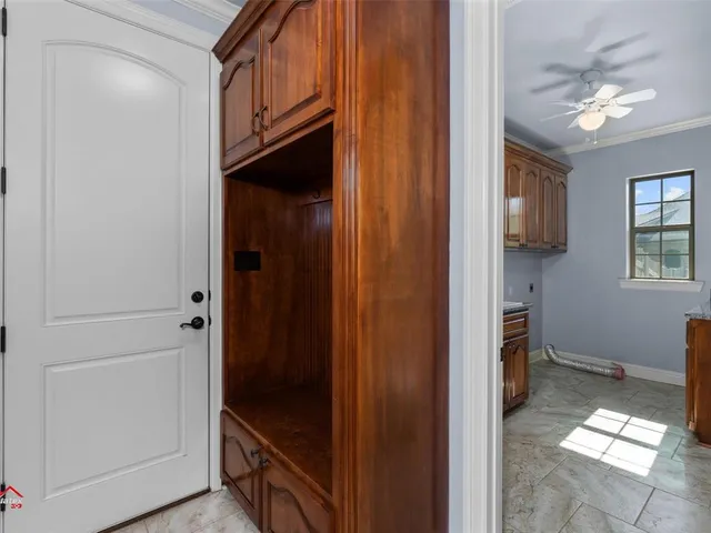 a utility room with stainless steel appliances granite countertop a sink a stove a washer dryer and cabinets