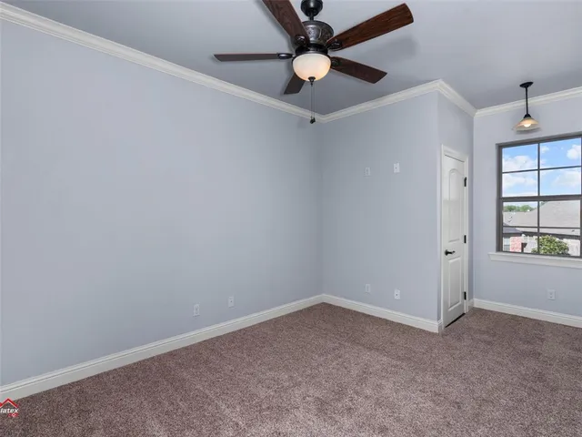 a bedroom with a bed furniture a flat screen tv and a window