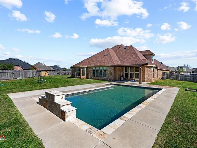a view of a backyard with swimming pool
