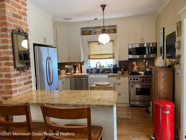 a kitchen with stainless steel appliances granite countertop a stove refrigerator and microwave