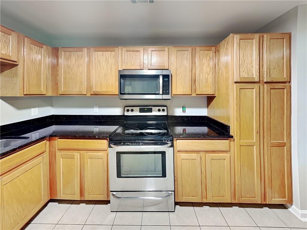 1020 Camelot Drive Atlanta, GA 30349 - Photo 5 of 17 a kitchen with granite countertop cabinets stainless steel appliances and a window