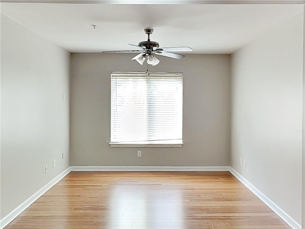 1020 Camelot Drive Atlanta, GA 30349 - Photo 8 of 17 an empty room with wooden floor chandelier fan and windows