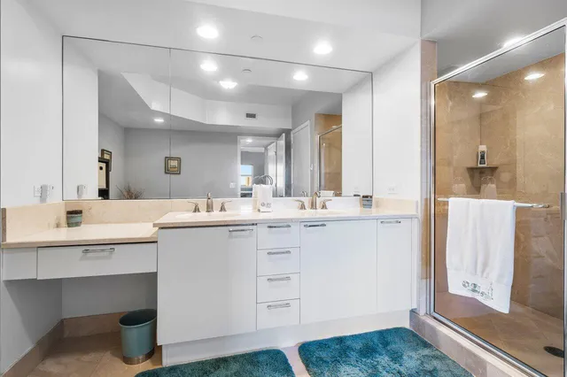 a bathroom with a shower sink vanity mirror and toilet