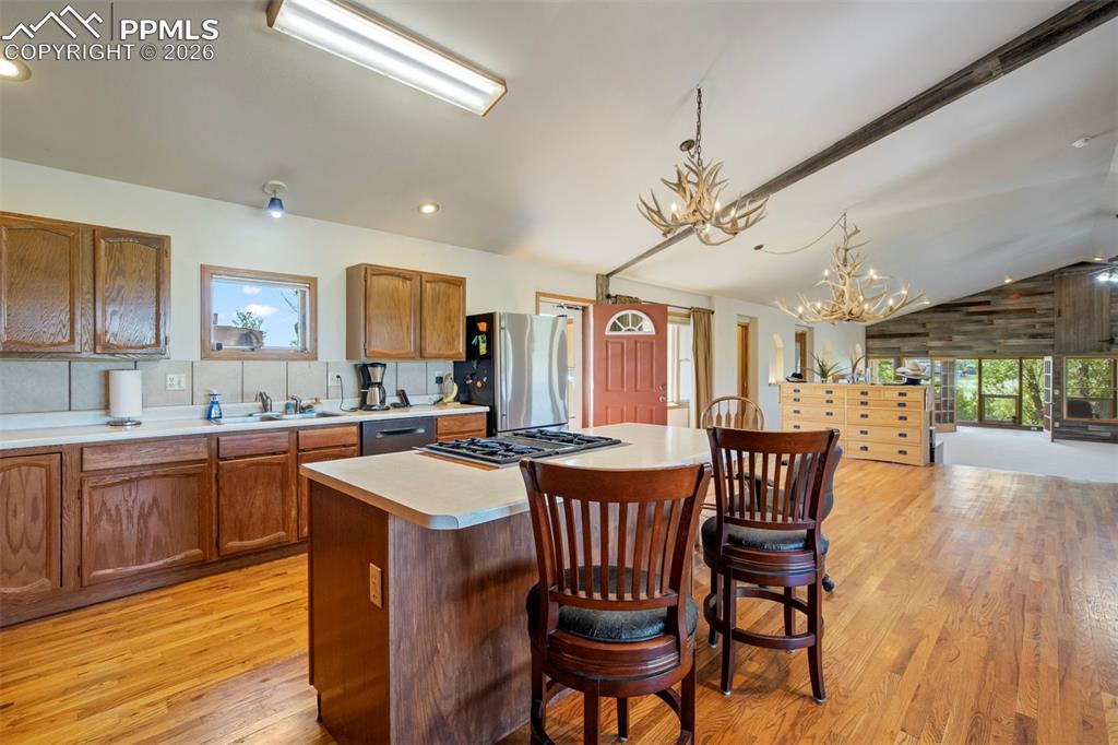 2550 Slocum Road Peyton, CO 80831 - Photo 18 of 49 a kitchen with stainless steel appliances granite countertop a sink a stove a dining table and chairs