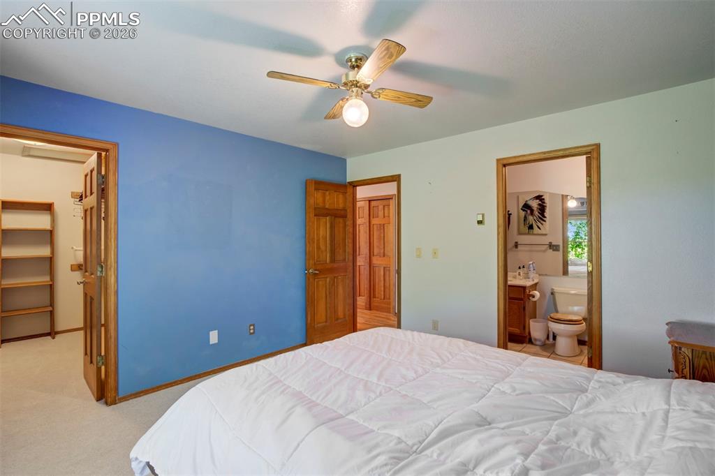 2550 Slocum Road Peyton, CO 80831 - Photo 28 of 49 a bedroom with a bed and a chandelier