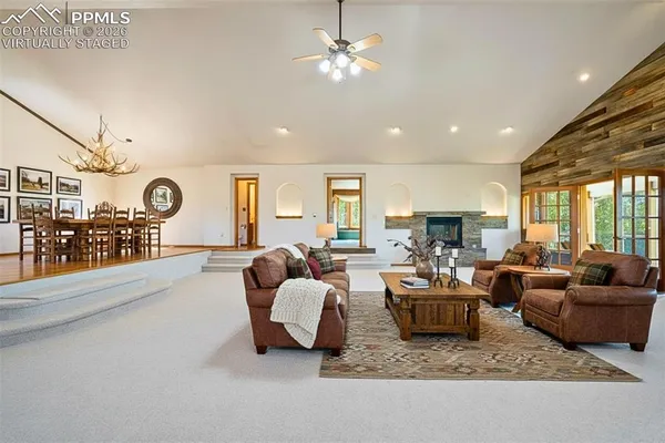 a view of a livingroom with furniture a chandelier and wooden floor