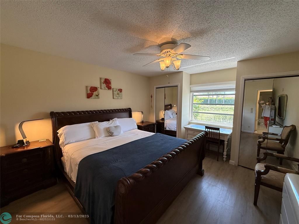 8540 Chevy Chase Drive, Unit 183 Boca Raton, FL 33433 - Photo 11 of 21 a bedroom with a bed and wooden floor