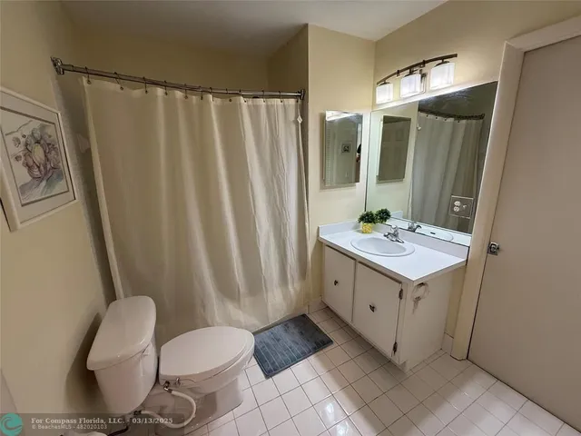 a bathroom with a sink vanity mirror and toilet