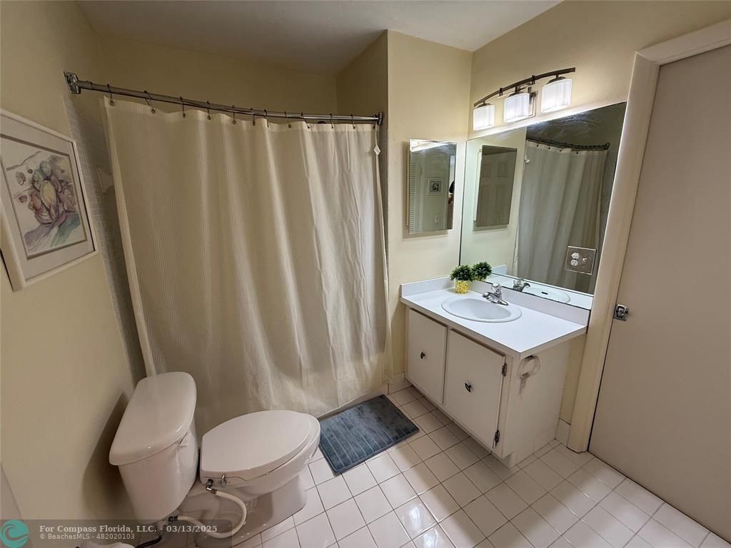 8540 Chevy Chase Drive, Unit 183 Boca Raton, FL 33433 - Photo 12 of 21 a bathroom with a sink vanity mirror and toilet