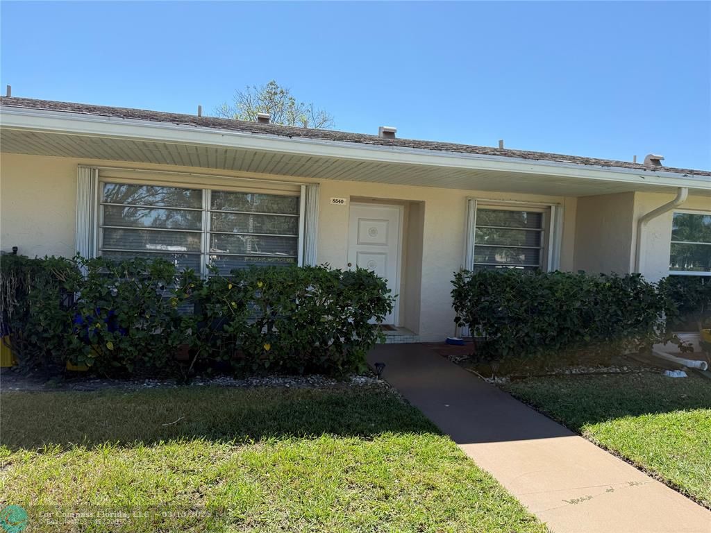 8540 Chevy Chase Drive, Unit 183 Boca Raton, FL 33433 - Photo 2 of 21 a front view of a house with garden