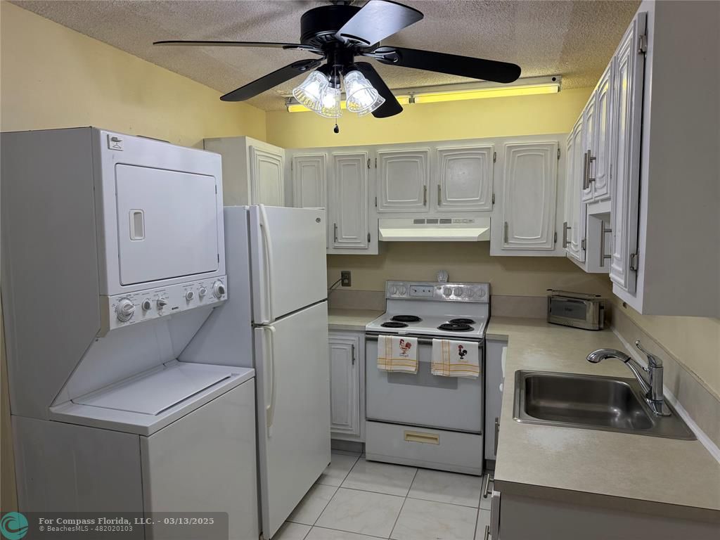 8540 Chevy Chase Drive, Unit 183 Boca Raton, FL 33433 - Photo 4 of 21 a kitchen with a stove cabinets and refrigerator