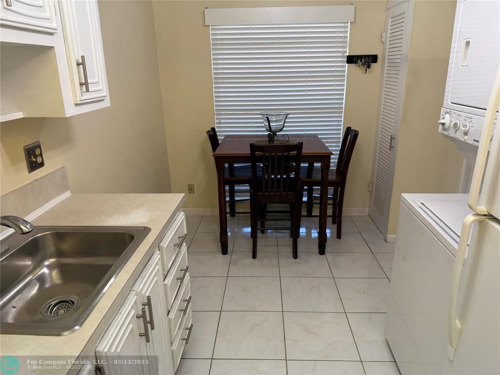 8540 Chevy Chase Drive, Unit 183 Boca Raton, FL 33433 - Photo 5 of 21 a kitchen with a sink a table and chairs