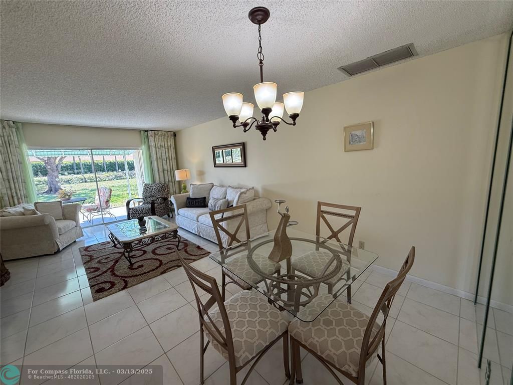 8540 Chevy Chase Drive, Unit 183 Boca Raton, FL 33433 - Photo 6 of 21 a view of a dining room with furniture a chandelier and a window