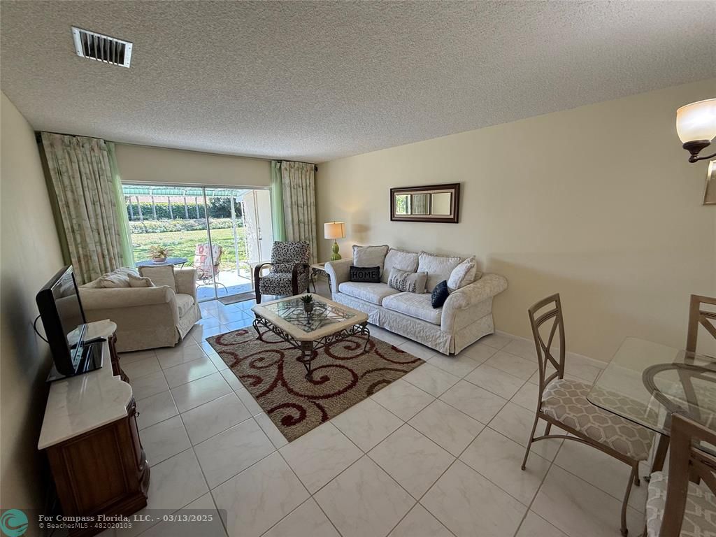 8540 Chevy Chase Drive, Unit 183 Boca Raton, FL 33433 - Photo 7 of 21 a living room with furniture and a large window