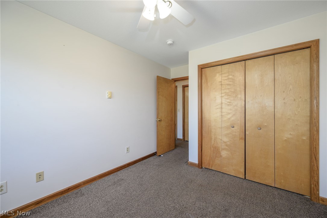 8464-8446 Tallmadge Road Diamond, OH 44412 - Photo 16 of 39 Unfurnished bedroom featuring carpet, a closet, and a ceiling fan