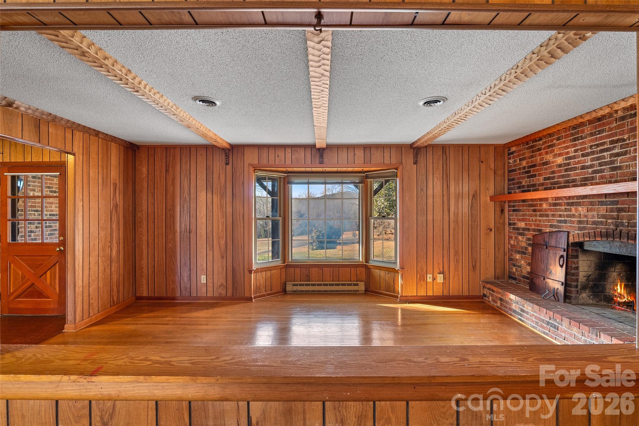 591 Landrum Road Tryon, NC 28782 - Photo 18 of 48 an empty room with floor to ceiling windows and fireplace