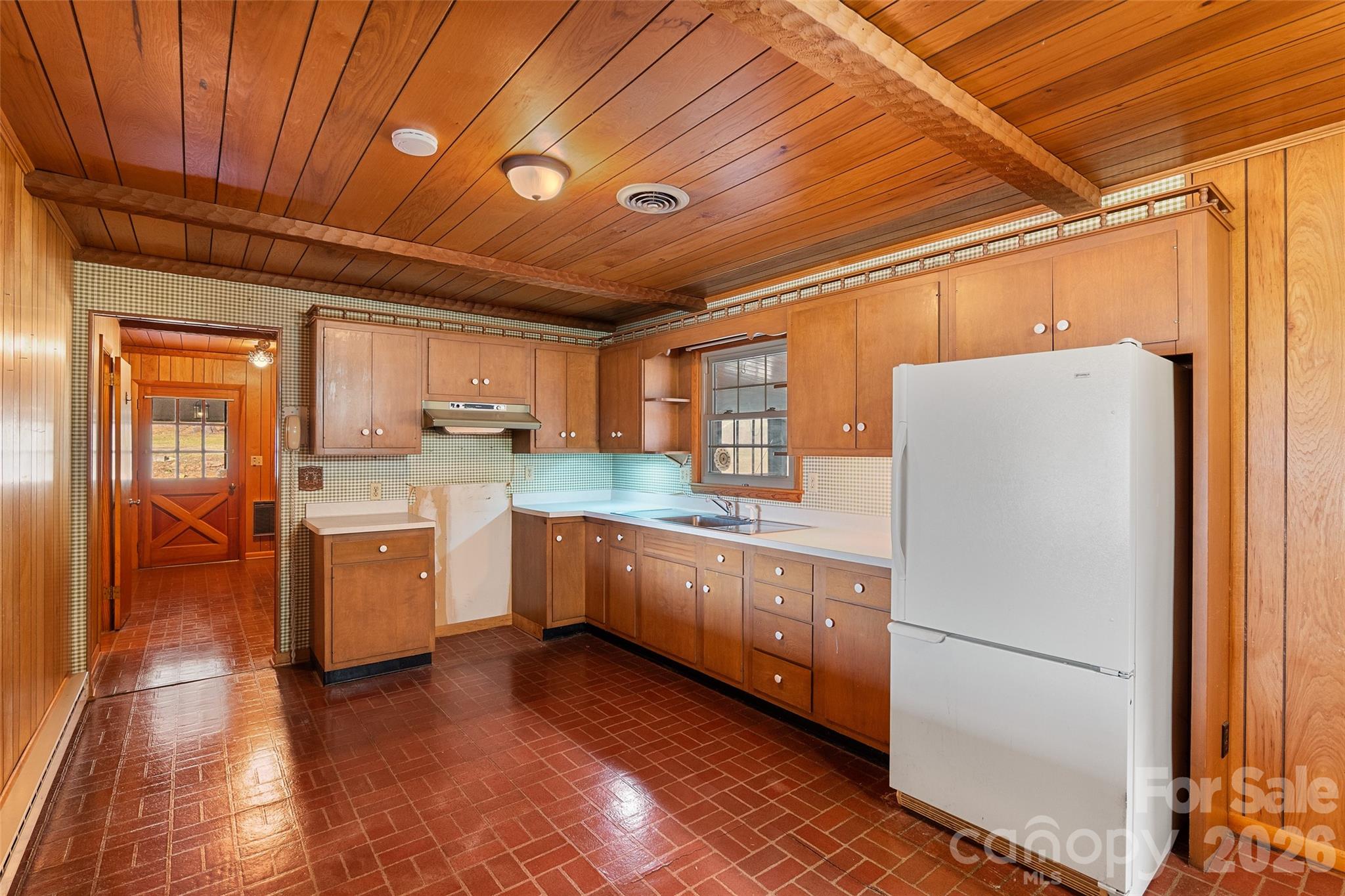 591 Landrum Road Tryon, NC 28782 - Photo 21 of 48 a kitchen with a refrigerator a sink and dishwasher with wooden floor